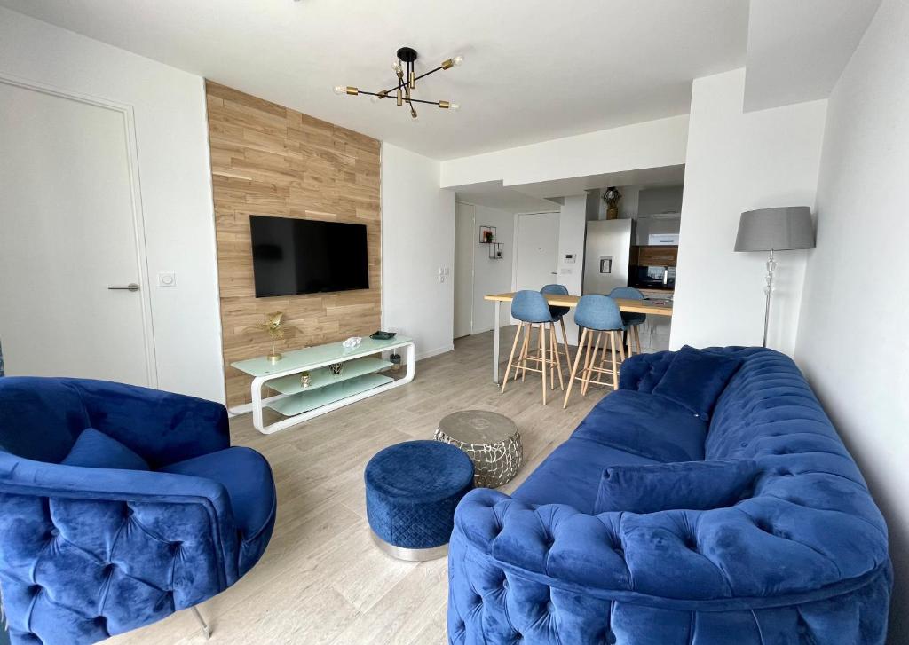 sala de estar con sofá azul y 2 sillas en La Marina - Proche Paris & Aéroport CDG, en Sevran