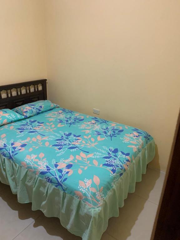 1 dormitorio con 1 cama con edredón azul en Habitaciones cómodas cerca de la playa en Montañita, en Montañita