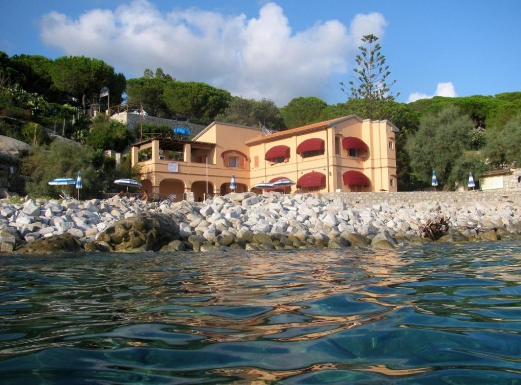 a building next to the water with a flock of birds at Onda Su Onda Appartamenti in Seccheto