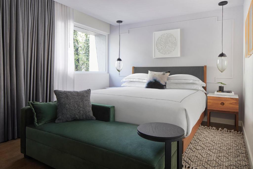 a bedroom with a bed and a green couch at Kimpton Virgilio in Mexico City