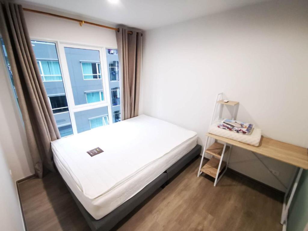 a small bedroom with a bed and a window at Bangkok Sathon RYE condo in Bangkok