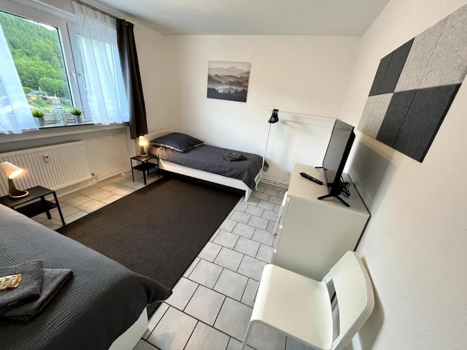 a room with a bedroom with a bed and a television at Bright & Cozy Apartment in Plettenberg