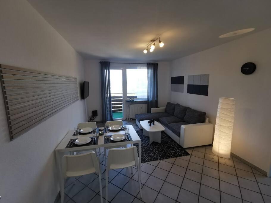 a living room with a couch and a table and chairs at Bright & Cozy Apartment in Plettenberg