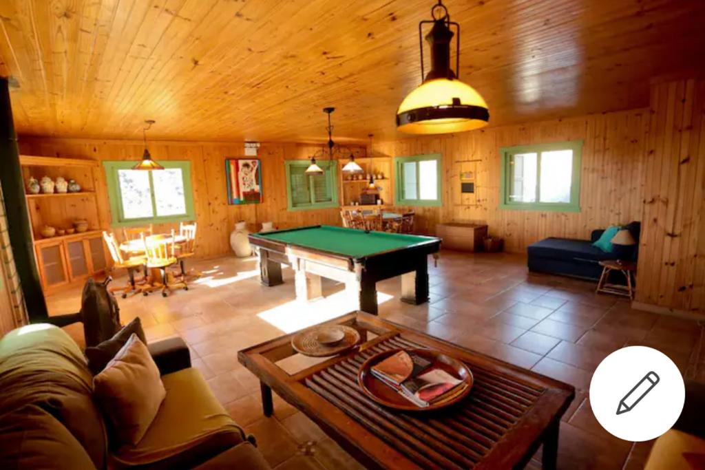 una sala de estar con mesa de billar en una cabaña en Pousada Villa dos Vinhedos en São Joaquim