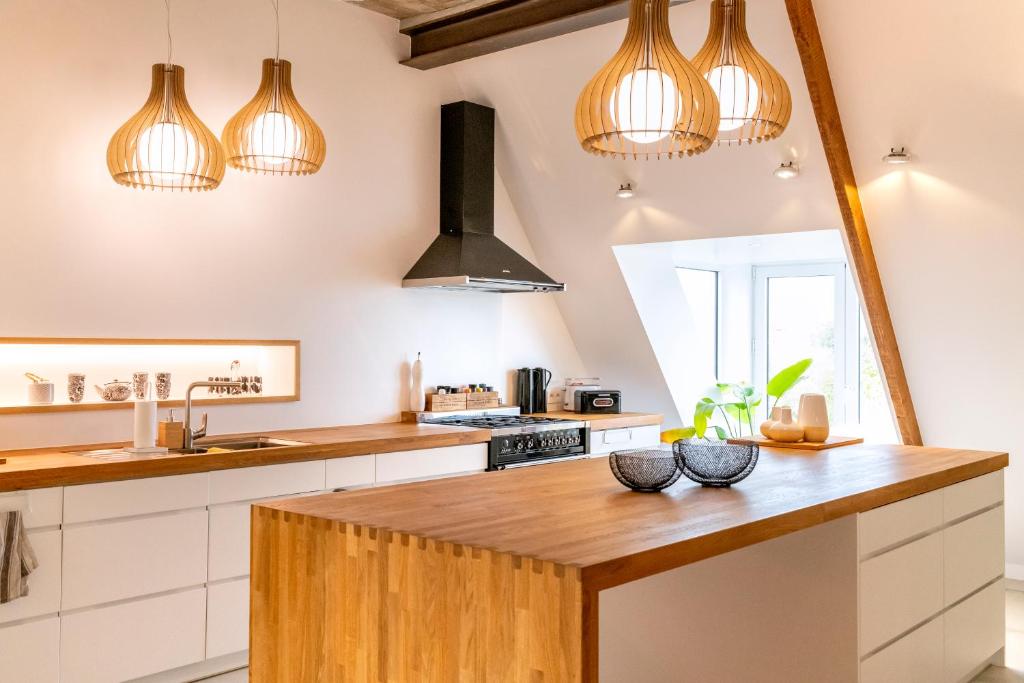 a kitchen with a wooden counter top and pendant lights at B&B Summertime in Koksijde