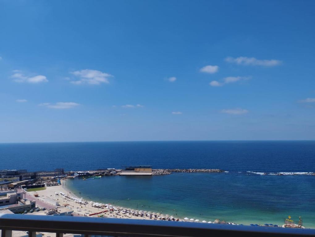a view of a beach and the ocean from a balcony at City Square - Apartments With Stunning Sea View in Alexandria