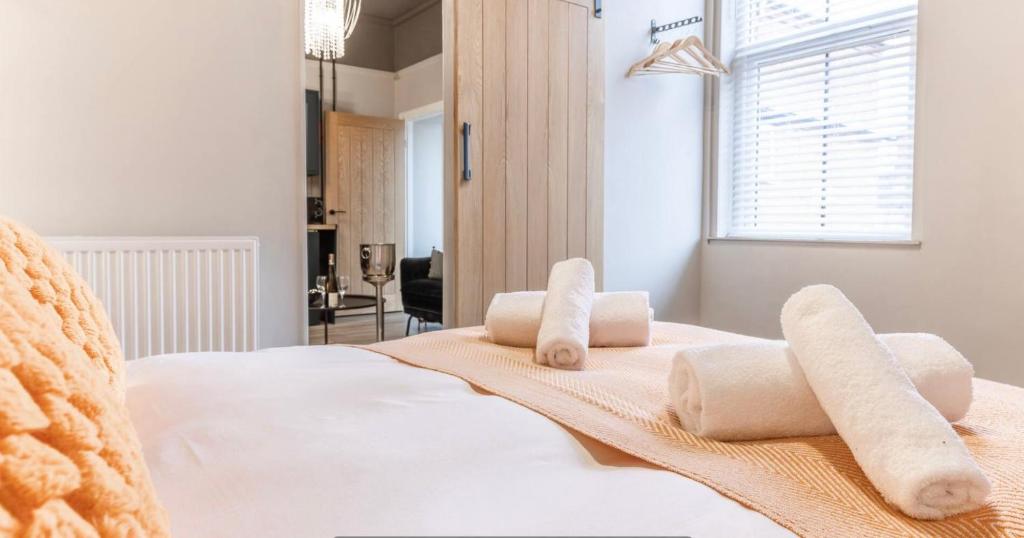 a bedroom with a white bed with towels on it at Modern boutique apartment for 4- central Ellesmere in Ellesmere