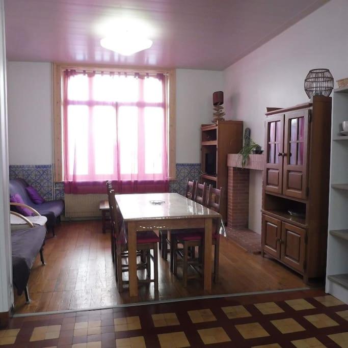 une cuisine avec une table et des chaises dans une pièce dans l'établissement Villa Wimereusienne, petite cour, à Wimereux