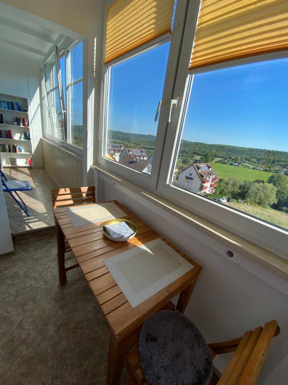 een kamer met een houten tafel en 2 ramen bij Apartment mit Loggia und Traumblick 