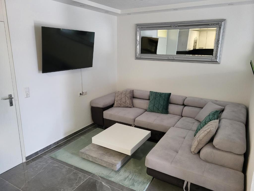 uma sala de estar com um sofá e uma televisão de ecrã plano em Schwarzwaldsuite mit Panorama Waldblick em Enzklösterle