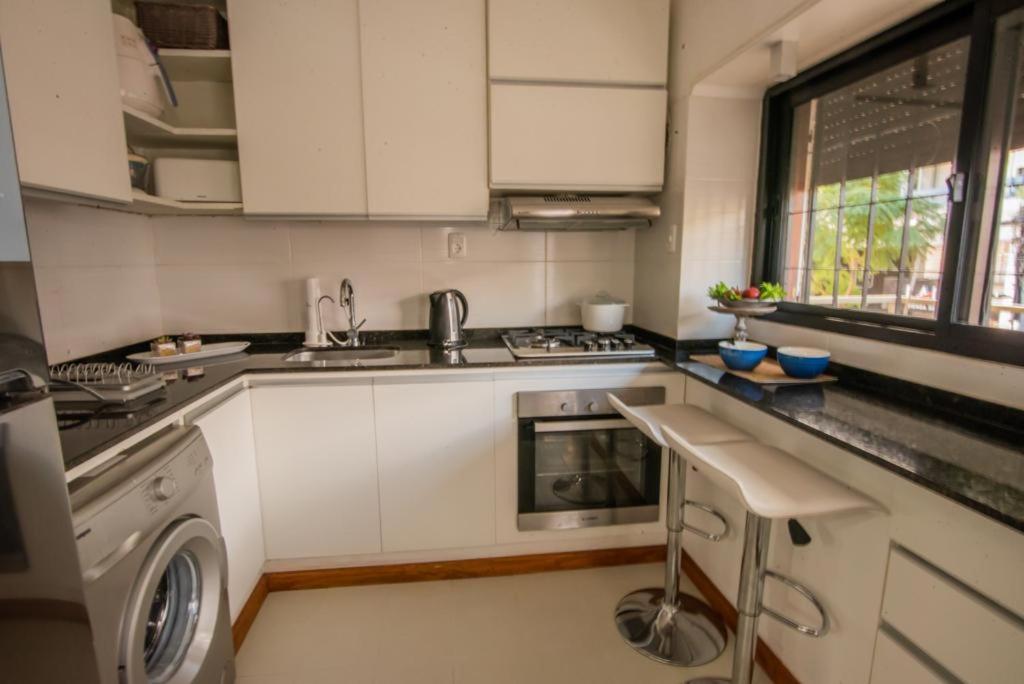 a kitchen with white cabinets and a washer at Exclusivo Apto Calle Principal in Salto
