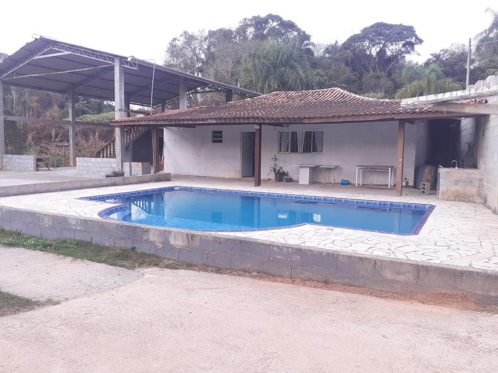 a swimming pool in front of a house at Sítio Araújo in Ibiúna