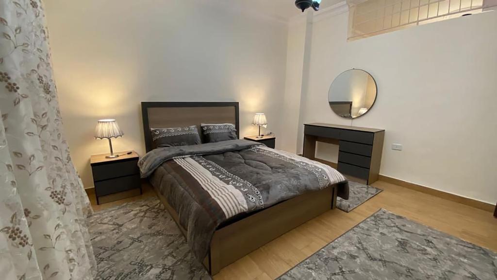 a bedroom with a large bed and a mirror at Amzing two bedrooms in the middle of amman in Amman