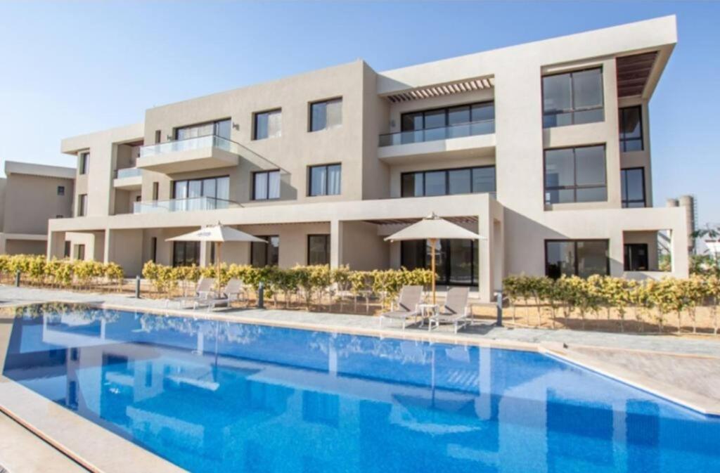 an exterior view of a building with a swimming pool at Salty life chalet, a two bedroom apartment by the swimming pool at Azha - Ain Sokhna - selected in the top 20 rentals to stay at in Sokhna in Ain Sokhna