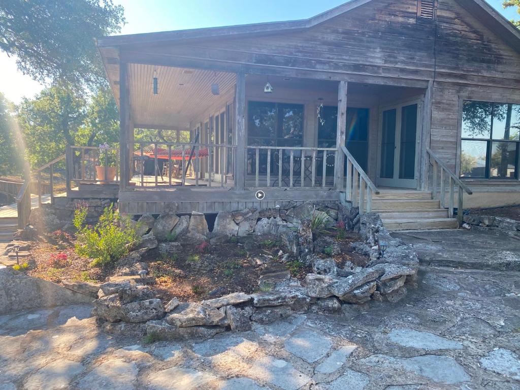 a small house with a porch and a rock garden at Around the Bend Bungalow in Fredericksburg