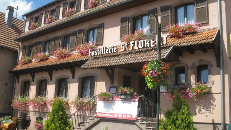 un hôtel avec des fleurs sur le côté d'un bâtiment dans l'établissement Hostellerie Saint Florent, à Oberhaslach