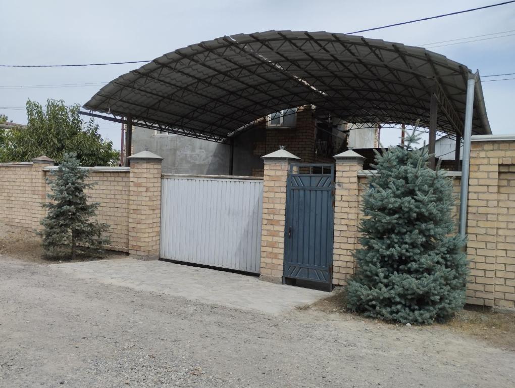 a house with a garage with a gate and a fence at Гостевой дом Энесай in Bishkek