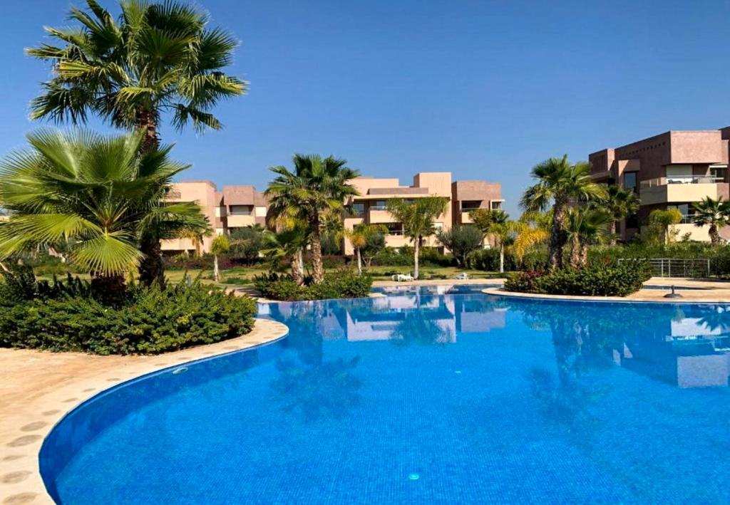 una grande piscina con palme e edifici di Condo à Prestigia Agate - Golf city Marrakech a Marrakech