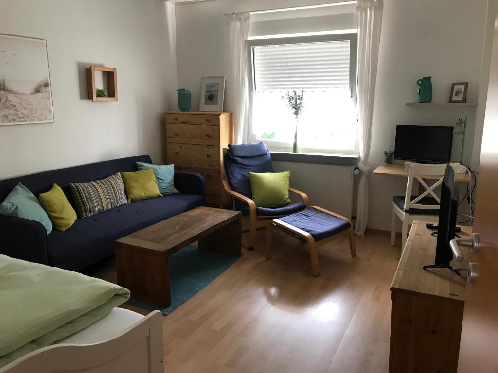 sala de estar con sofá azul y mesa en Auszeit im Pott - Ferienwohnung Minze en Herten