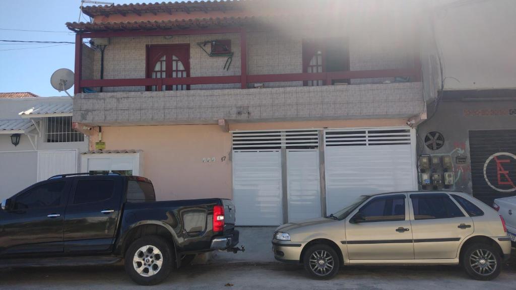 een vrachtwagen en een auto geparkeerd voor een gebouw bij Casa de Praia completa em Cabo Frio 6 para até 5 pessoas in Cabo Frio