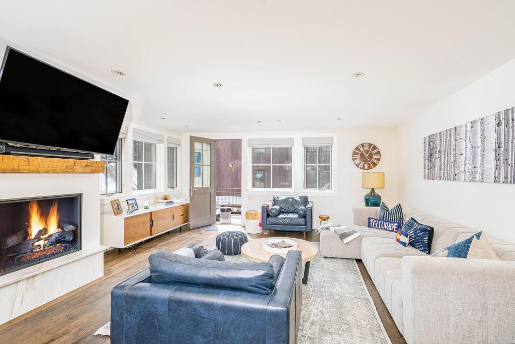 a living room with a fireplace and a tv at 330 W Pacific B townhouse in Telluride