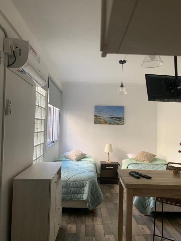 een kleine kamer met 2 bedden en een bureau bij Sweet Home in Vicente López