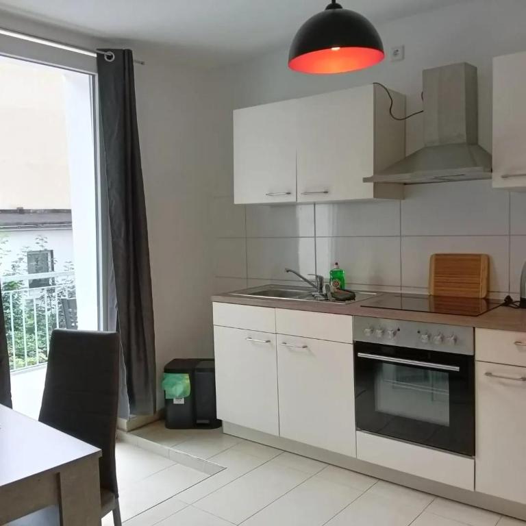 a kitchen with white cabinets and a stove top oven at Stellas Monteurswohnungen in Crimmitschau