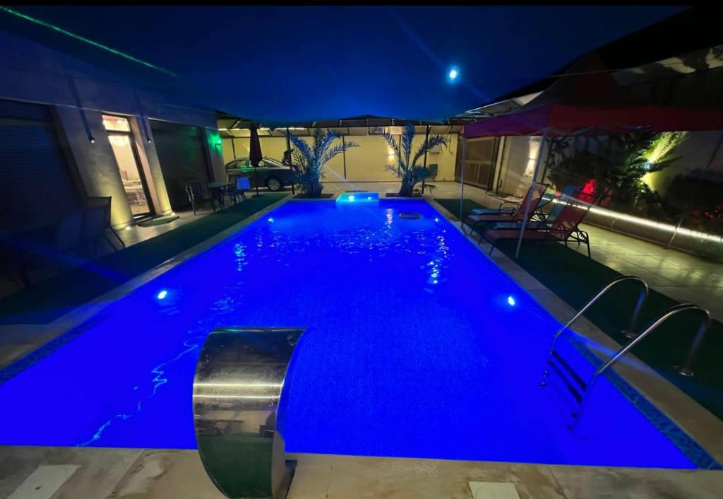 a swimming pool at night with blue illumination at شاليه الهيبة alhaybeh chalet in Amman