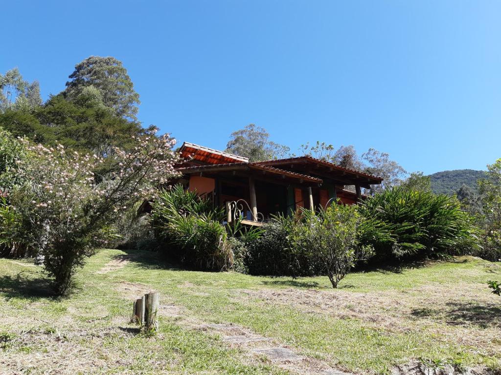 a house sitting on top of a grass field at Chalé Aconchegante, Paz e Natureza in São Francisco Xavier