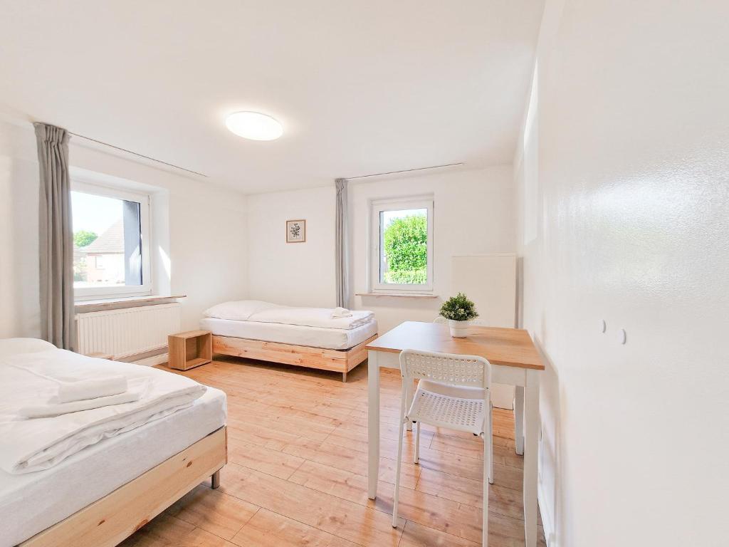 um quarto com uma secretária, uma cama e uma mesa em RAJ Living - 3 Room Apartments - 20 Min to Messe DUS & Old Town DUS em Meerbusch