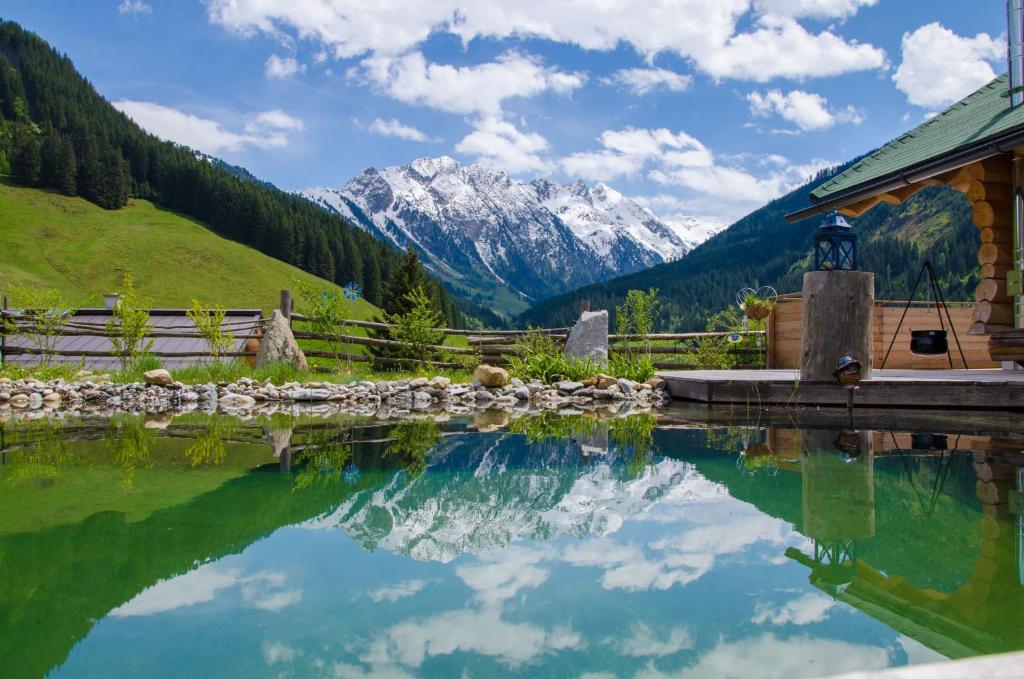 uma piscina de água com montanhas ao fundo em Der Grubacher em Gerlos