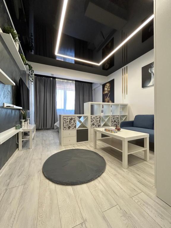 un soggiorno con divano e tavolo di Perla Home - Studio 26 a Popeşti-Leordeni