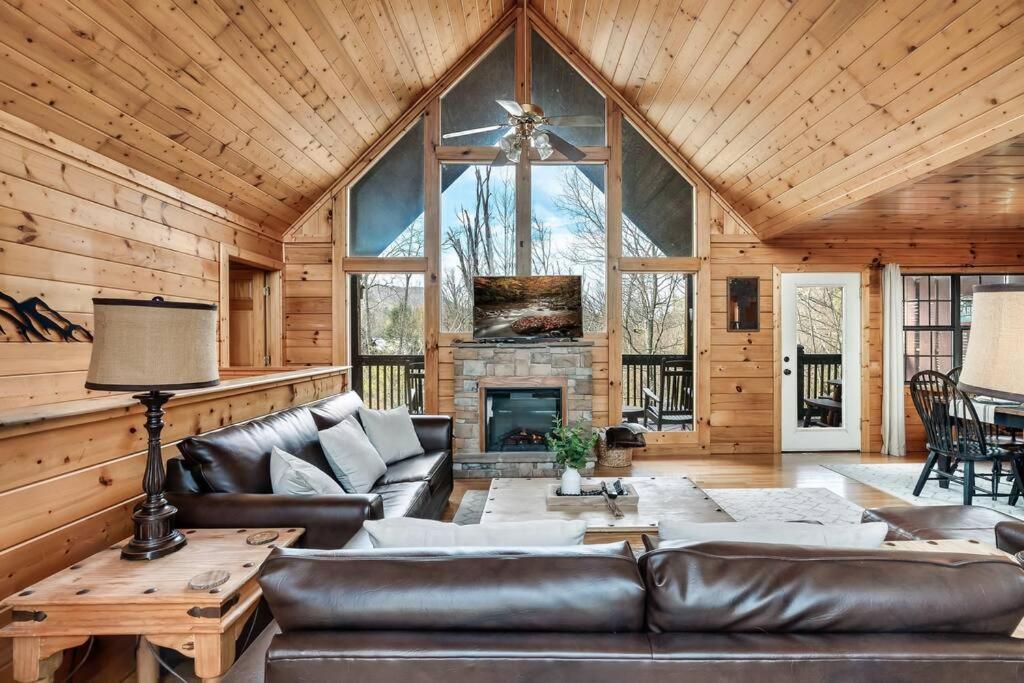 a living room with a couch and a fireplace at Kate's Cabin - 3 min to Dollywood! Cabin with Hot tub, Game Room, and Resort Pool! in Sevierville