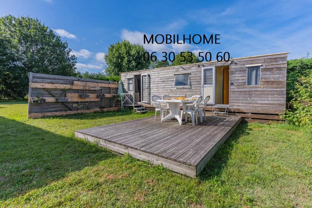 una terrazza in legno di fronte a una casa mobile di Chez Lionel & Mathéis , joignable au zéro6trente53cinquante60 a Biscarrosse