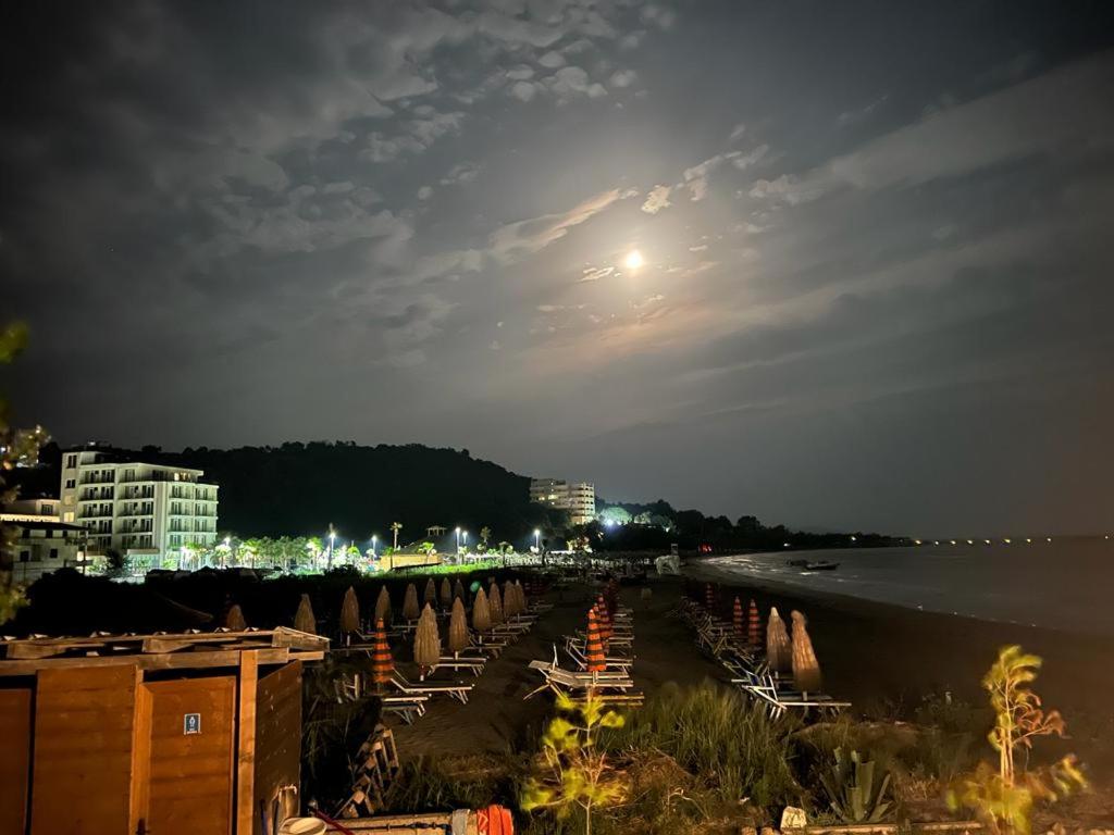 een strand 's nachts met de maan in de lucht bij Apartament i kendshem in Kavajë