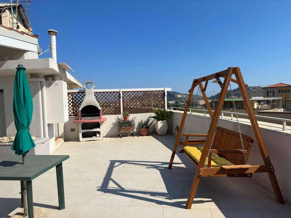 a patio with a hammock on a roof at Nuovo attico con terrazza 5 minuti dal mare in Cagliari