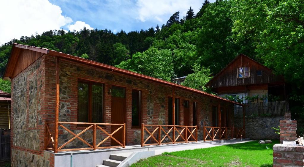 a small brick building with trees in the background at Borjomi Cottages in Borjomi