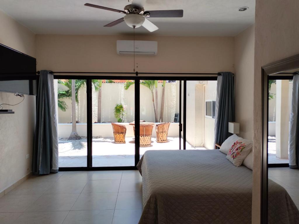 莫雷洛斯港的住宿－Cabañas Puerto Morelos，一间卧室配有一张床和吊扇