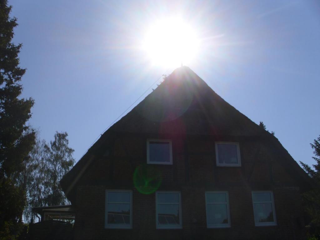 a house with the sun shining behind it at Alte Försterei in Mustin