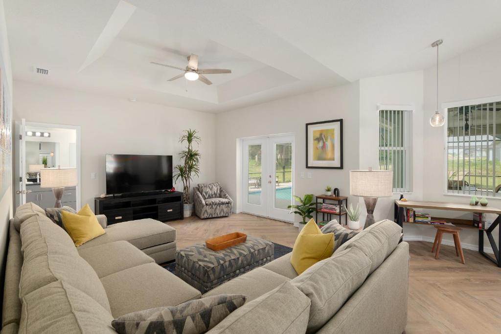 a living room with a couch and a tv at Villa Ilse: New Stylish Home With Private Pool in Inverness