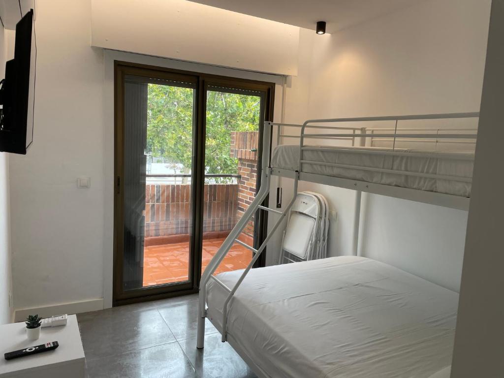 een slaapkamer met 2 stapelbedden en een balkon bij C3 Exclusiva zona Madrid in Madrid