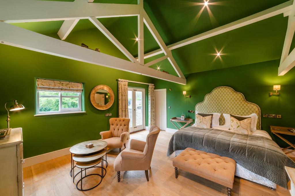 ein Schlafzimmer mit grünen Wänden, einem Bett und einem Tisch in der Unterkunft The Blue Lion in East Witton