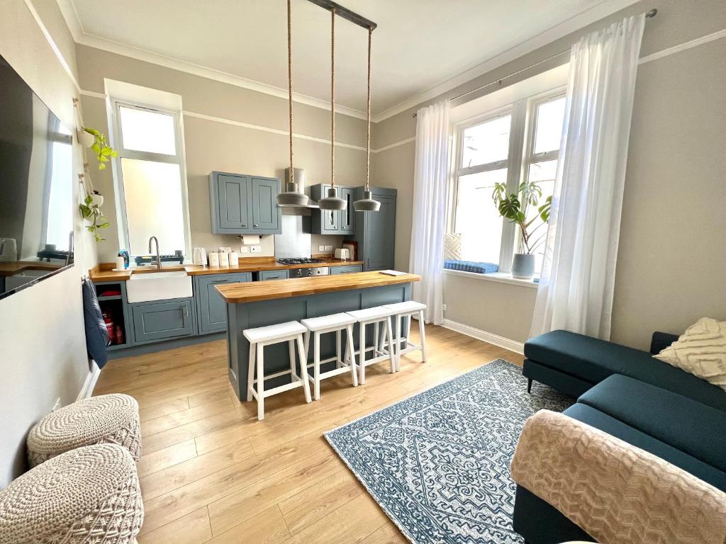 uma sala de estar com um sofá e uma cozinha em Lossie Self-Catering Apartment em Lossiemouth