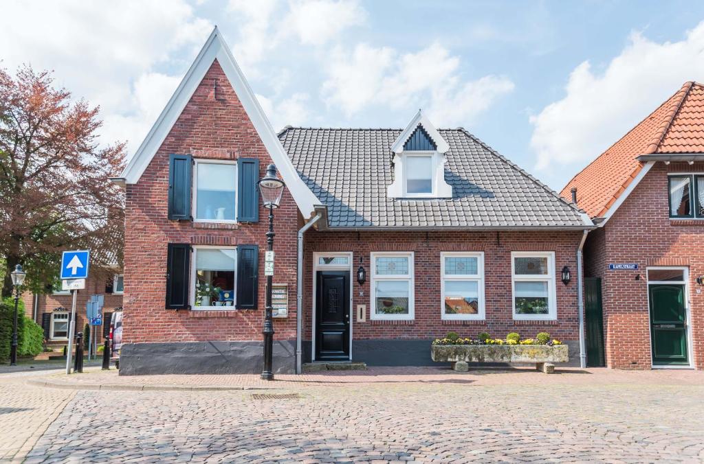 een stenen huis op straat met een bankje ervoor bij vakantiewoning Stadszicht in Ootmarsum