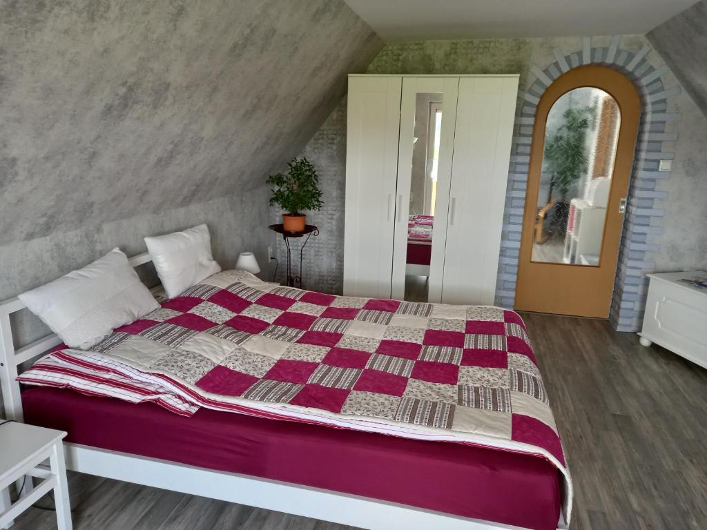 a bedroom with a large bed with a purple comforter at Ferienwohnung, Urlaub im Frankenwald in Konradsreuth