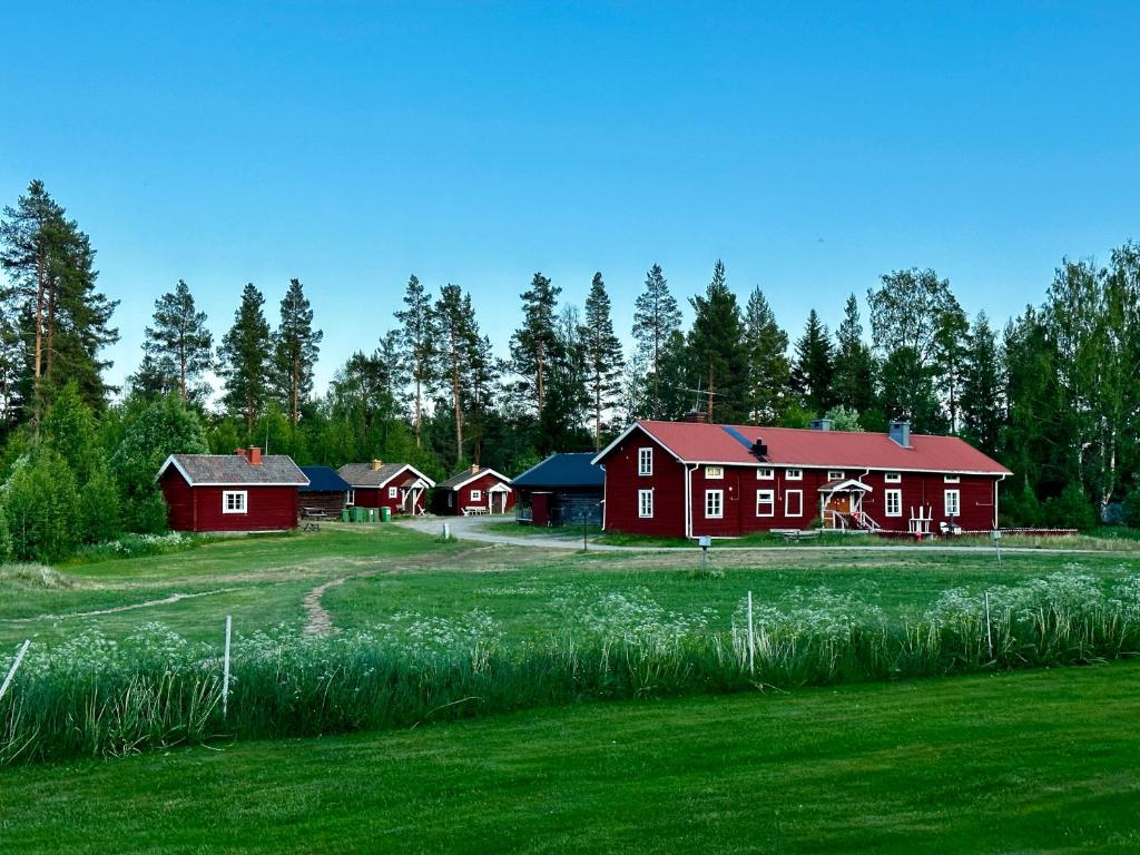 un grupo de graneros rojos en medio de un campo en Ramsjö Camping Stuga, en Ramsjö