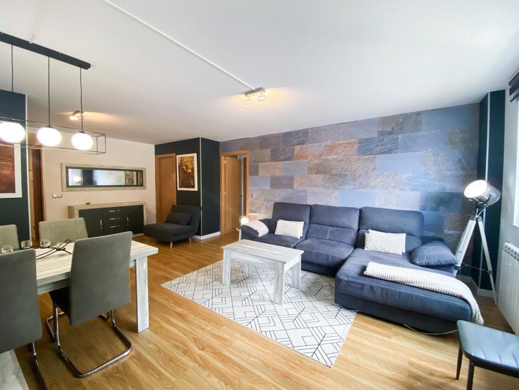 a living room with a blue couch and a table at Terraza con Increibles Vistas Para 8 personas - 3 habitaciones - 2 baños - ARINSAL - FREE PARKING in Arinsal