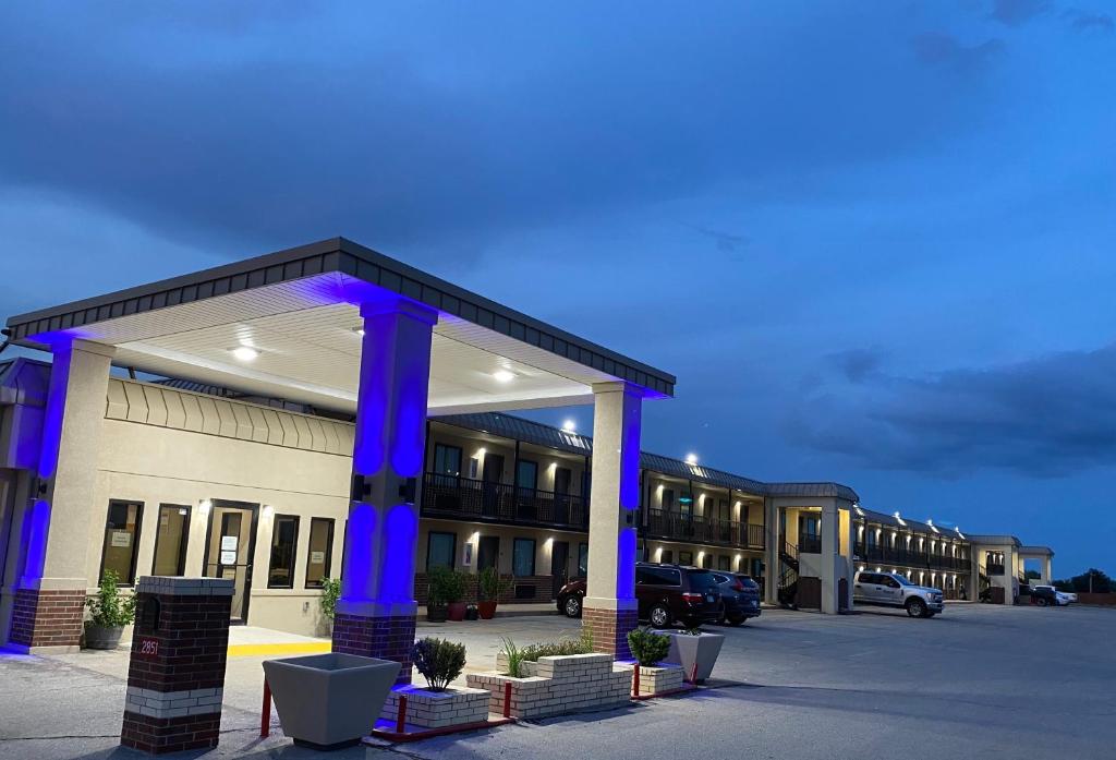 a large building with blue columns in a parking lot at Hotel 81 El Reno in El Reno