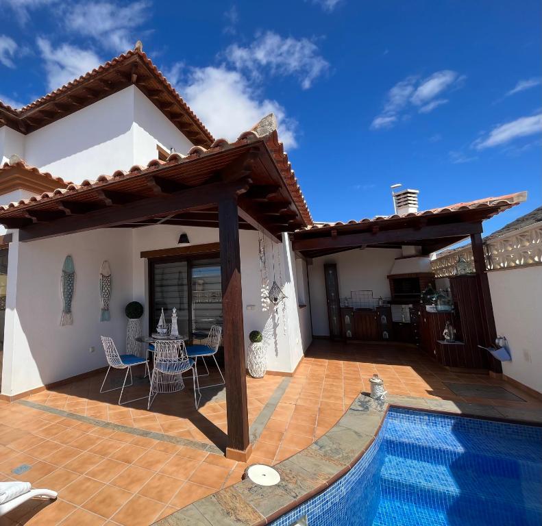 a villa with a swimming pool and a patio at Casa Mararía in Gran Tarajal