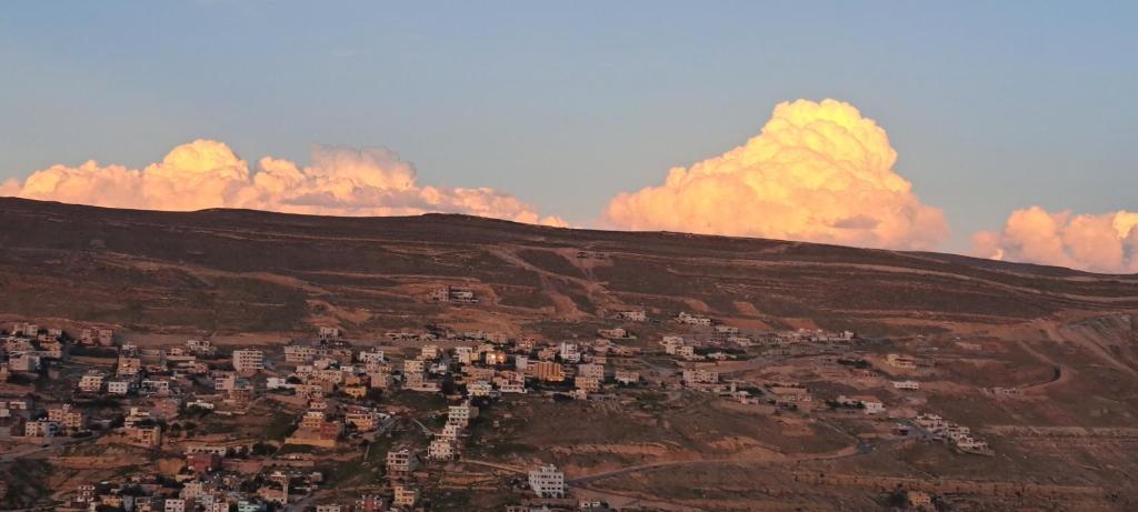 a city on a hill with clouds in the sky at Leen Guest House in Wadi Musa